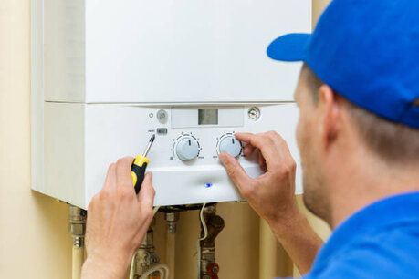 plumber heating engineer - professional looking at a boiler
