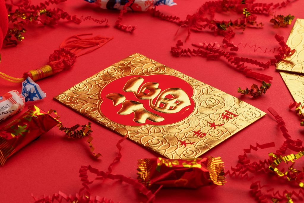 CommunityAd Trades - Activities - gold envelope with Chinese character on red table cloth for Chinese New Year