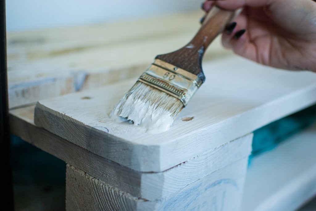 CommunityAd Trades - Carpentry & Joinery - person painting wooden furniture white with brush