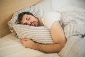 CommunityAd Trades - Health & Wellbeing - man sleeping on bed while hugging duvet