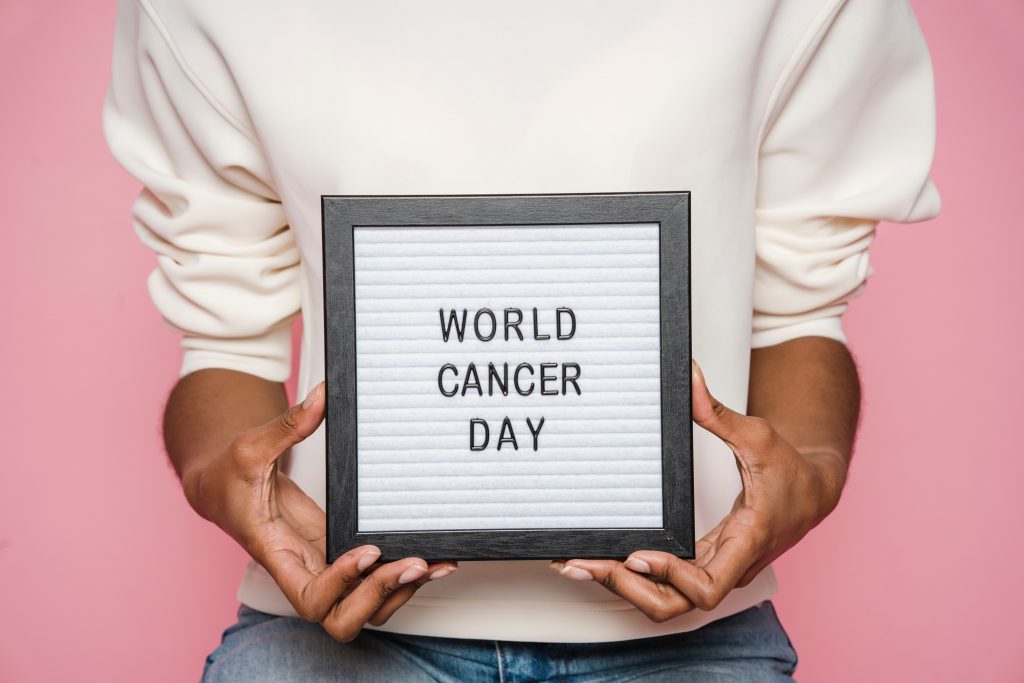 CommunityAd Trades - Charities - a woman holding a sign that says World Cancer Day